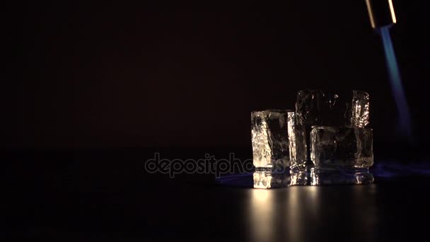 Quema de alcohol con un encendedor alrededor de cubos de hielo — Vídeos de Stock