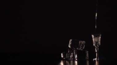 Alkol içki bir cam ve eriyen buz içine dökme yandı