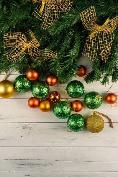 Holiday New Years decorations. Christmas tree with many green and red balls near and golden bows on it — Stock Photo, Image