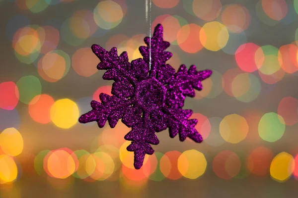 Рождественские украшения. Закрыть фото новогодней фиолетовой снежинки. Хорошая игрушка в цветном свете — стоковое фото