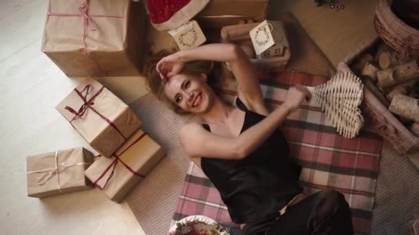Joven chica sexy está mintiendo entre los regalos y decoraciones de Navidad — Vídeo de stock