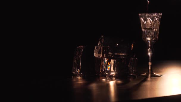 Выливание самбуки в стакан возле пирамиды из кубиков льда — стоковое видео