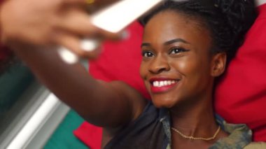 Komik selfies yatakta yatarken yapma güzel Afrikalı-Amerikalı kız portresi