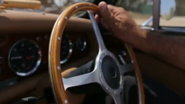 Gubbe med brons hud förvandlas ratten i en gammal bil — Stockvideo