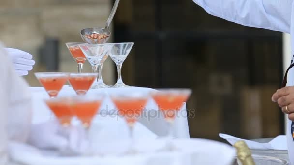 Man giet punch in cocktail glazen — Stockvideo