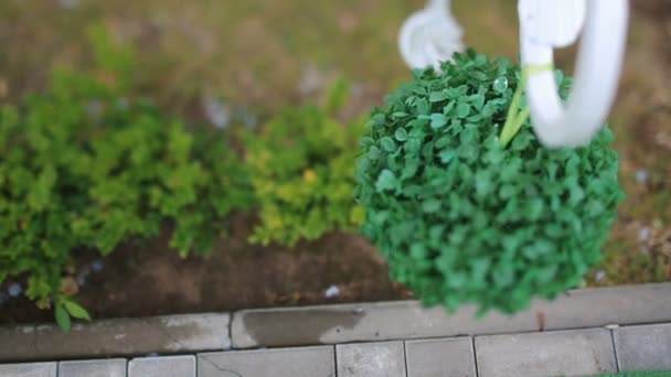 Bola verde decorativa cuelga sobre el pavimento — Vídeo de stock