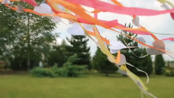 Wind weht bunte Bänder und Papierherzen — Stockvideo