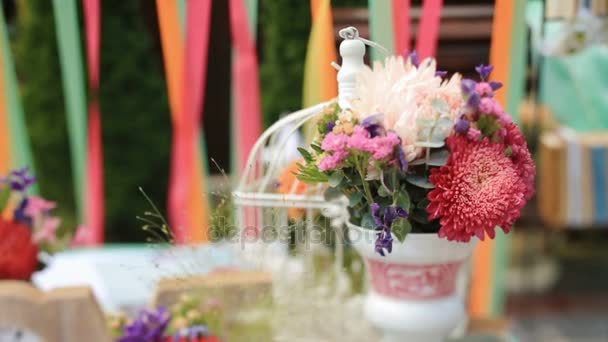 Táblázat díszített fa betűkkel szerelem, fehér madár kalitka és virágok esküvői oltár előtt áll — Stock videók