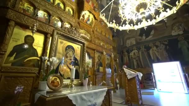 Golden icon stands on wooden table before iconostasis — Stock Video