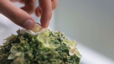 Adam küçük bej çiçek düğün yüzük alır