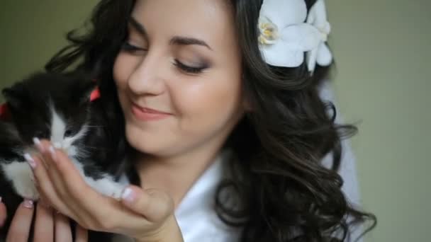 Esmer gelin sevimli kedicik kırmızı yay ile tutar — Stok video