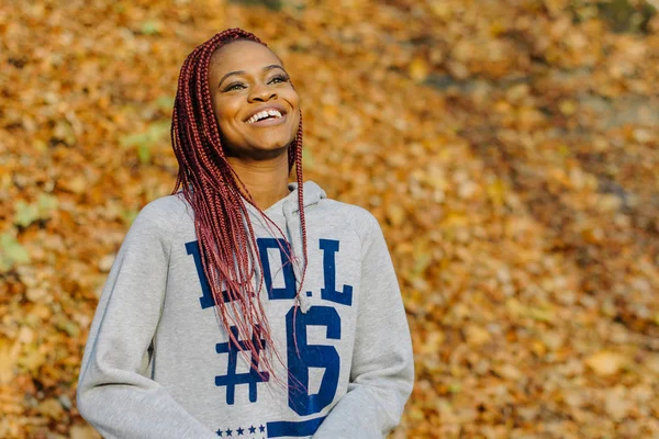 Retrato al aire libre de otoño de una hermosa joven afroamericana sonriendo en el parque. Gente negra — Foto de Stock