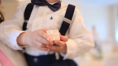 Beyaz gömlekli küçük çocuk küçük hediye kutusu tutar