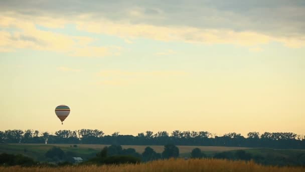 Färgglad ballong flyger över lilla stad — Stockvideo