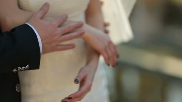 Жених обнимает невесту сзади, нежно держа ее за руки. — стоковое видео