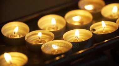 Küçük bir tepsi üzerinde satırlardaki ayakta yanık mumlar