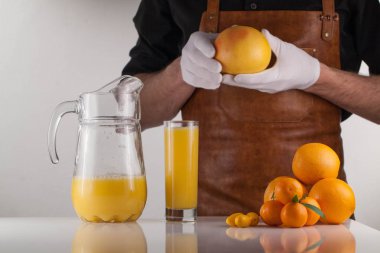 Turuncu cam og portakal suyu ve portakal yukarıda holding eller mans