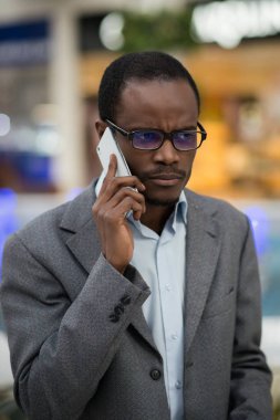 Afro-Amerikan adam ciddi konuşma telefonda vardır.