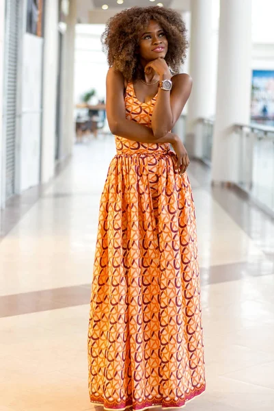 Ganska afrikansk flicka med lockigt hår stående i ett köpcentrum. — Stockfoto