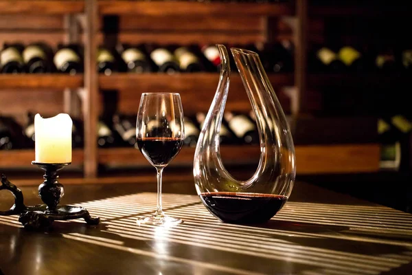 Bicchiere di vino e bottiglia di vino figurato posto su un tavolo in una volta di vino . — Foto Stock