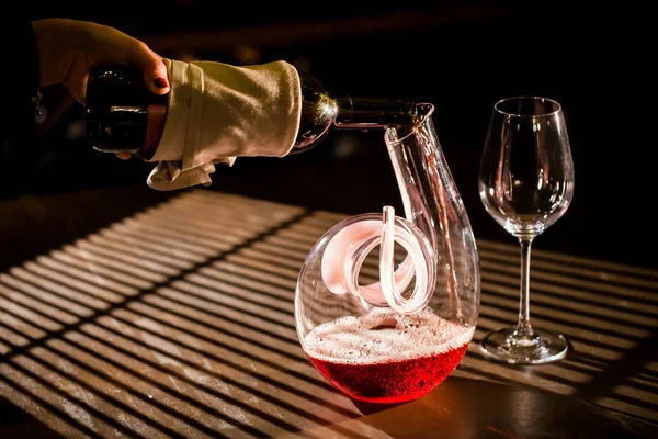 Композиция на бутылке вина, графин и бокал вина. Вино, разливающееся из бутылки в графин . — стоковое фото
