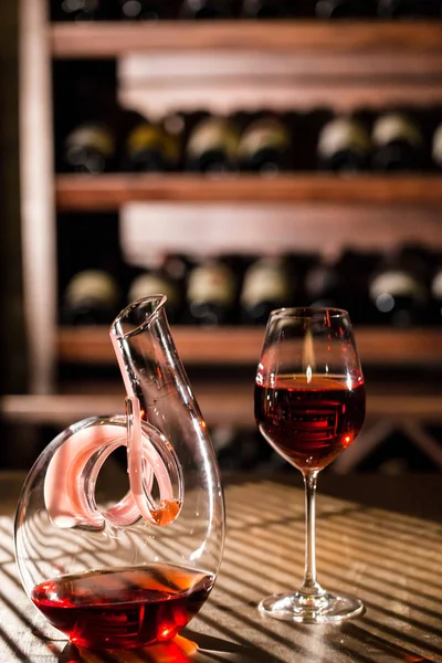 Wine vault location. Wine carafe and wine glass placed on a wooden table. — Stock Photo, Image