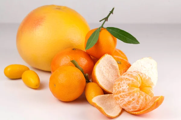 Sappige rijpe grapefruit met mandarijnen op een witte achtergrond — Stockfoto