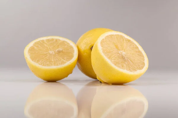Composotion if two ripe lemons. On is cut into halves. White background — Stock Photo, Image