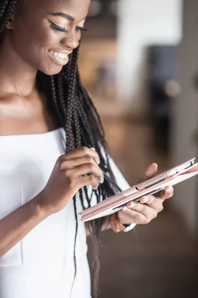 Usmál se africká americká dívka s tabletem v ruce. — Stock fotografie