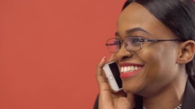 Kırmızı arka plan telefonda konuşurken mutlu afroamerican işkadını
