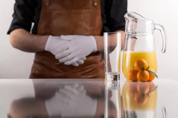 Mann steht hinter der Komposition aus Orangensaftglas und ein paar Mandarinen daneben. Konzept eines gesunden Lebensstils — Stockfoto