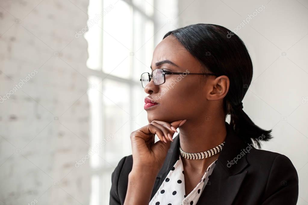 Portrait of african american woman wearing official clothes and glasses.