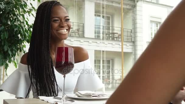 Dos amigos afro-americanos de moda están bebiendo vino en el restaurante para celebrar su reunión — Vídeo de stock