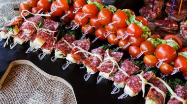 Domates, sosis ve peynir ahşap oyun tahtası ile kanepe.