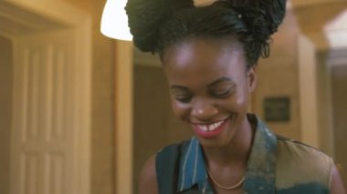 Trendy giymiş Afro-Amerikan kadın kahverengi Afrika pigtails ile masa futbolu oynuyor. Duyguları kazanan