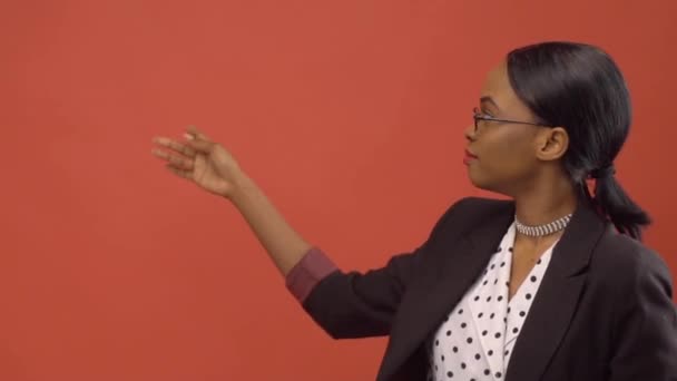 Czarny Kobieta rozmawia o temacie stojące przed czerwone ściany — Wideo stockowe