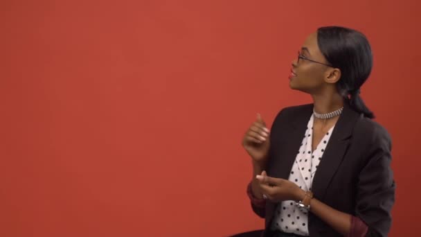 Busy black woman dressed in business style talks about something before the wall — Stock Video