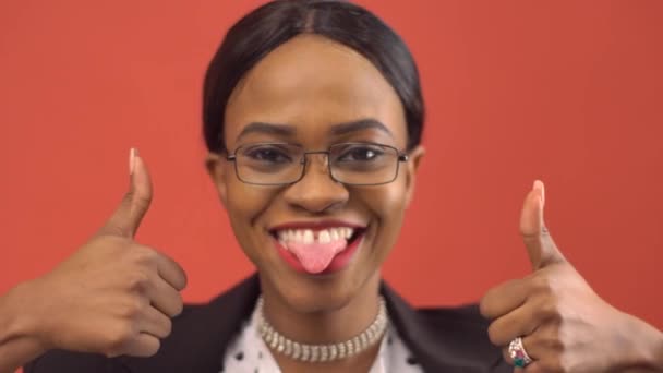 Sonriente dama negra muestra los pulgares hacia arriba y su lengua — Vídeos de Stock