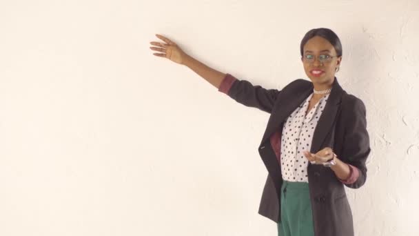 Бізнес-леді обговорює щось, що стоїть перед білою стіною — стокове відео