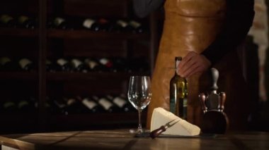 Sommelier mantar şişe açacağı kullanarak ve cam beyaz şarap ile doldurma dışarı olmaya başladı. Peynir ve şarap kadehi masaya yerleştirilir.