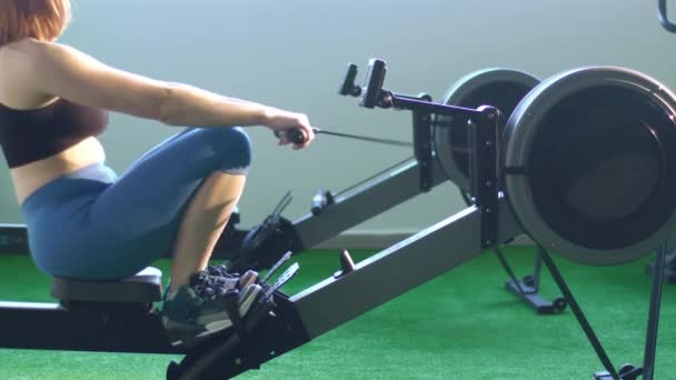 La photo en gros plan de la femme qui s'entraîne sur le formateur dans la salle de gym verte . — Video