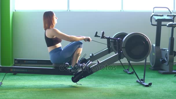 La foto lateral de la mujer haciendo ejercicios en el entrenador para mejorar sus músculos del culo y las piernas . — Vídeo de stock