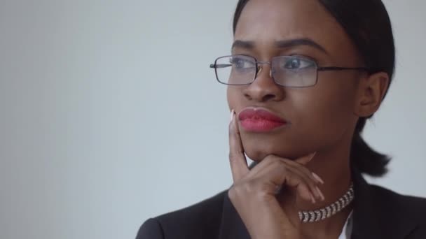 Thouhgtful mujer negra sostiene sus dedos debajo de la barbilla — Vídeos de Stock