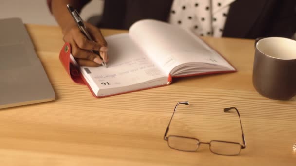 Primer plano de las mujeres mano escribiendo algo en el cuaderno — Vídeos de Stock