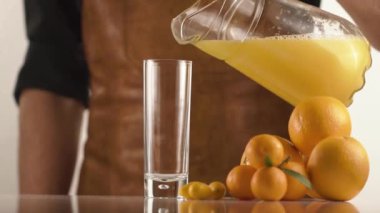 Deri önlük adam masada portakal ve mandalina suyu dökülen