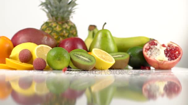 Bitar av granatäpple faller på bord med exotiska frukter — Stockvideo