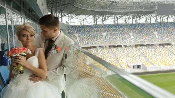 Charmante jonggehuwden staan praten op het voetbalstadion — Stockvideo