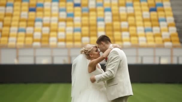 Nowożeńcy pocałunek na boisko zielone — Wideo stockowe