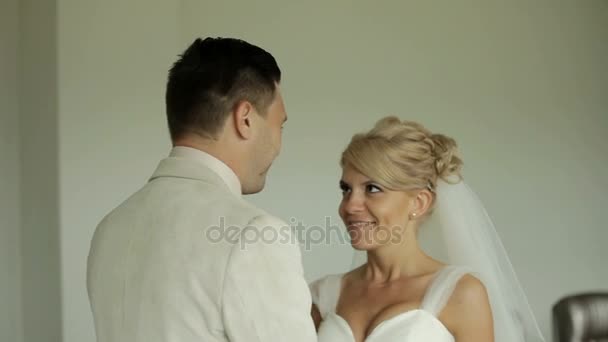 Жених целует невесту после того, как она садится на стол — стоковое видео