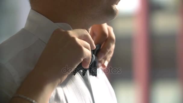 Жінка фіксує оксамитову краватку на шиї чоловіка — стокове відео